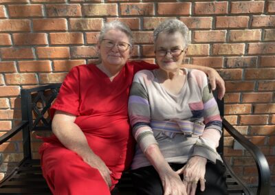 rehab staff and patient sitting on a bench smiling