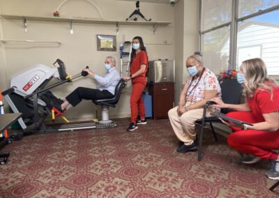 staff and patients in an exercise room with a bike