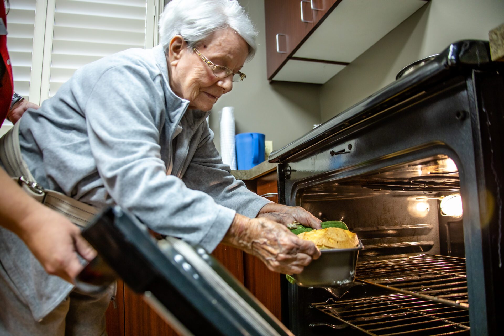 woman helping a patient use an exercise band